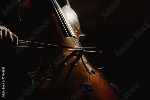 Silhouette of a cello against a black background