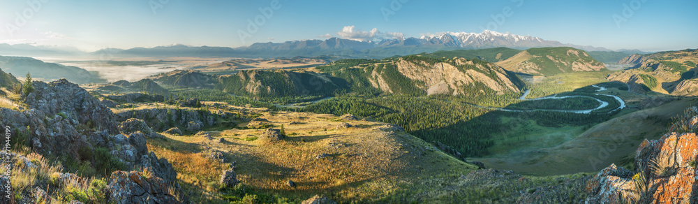 Above a picturesque mountain valley with a river, evening light, panoramic view	