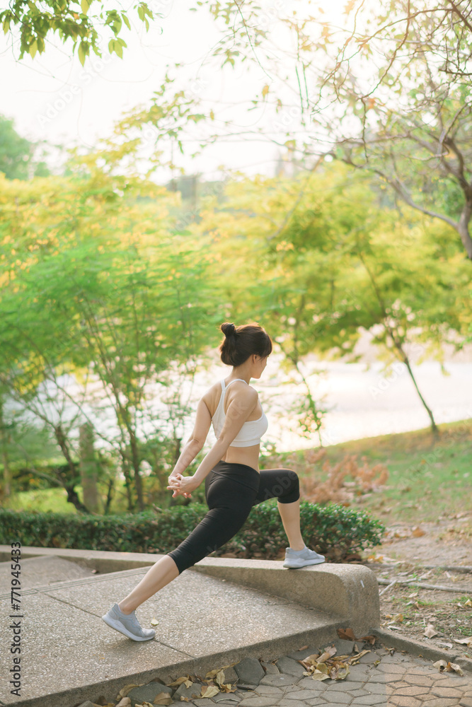 Female jogger. Fit young Asian woman with sportswear stretching muscle in park before running and enjoying healthy outdoor. Fitness runner girl in public park. Wellness being concept