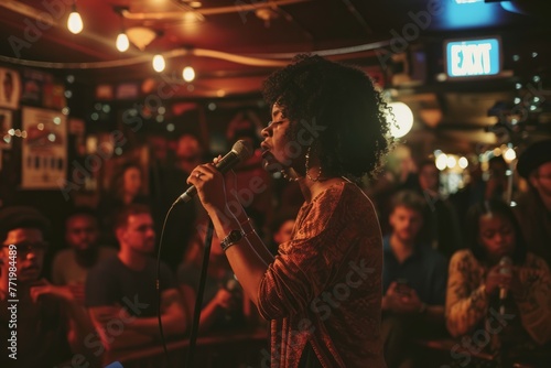 A woman confidently sings into a microphone in front of a crowd during an open mic night at a local venue