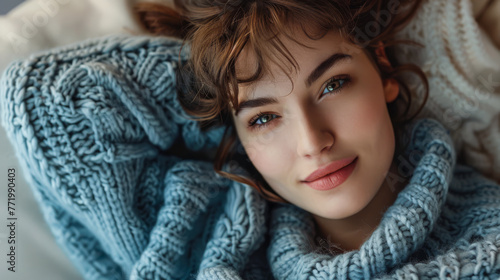 Portrait of a young beautiful woman at home wearing a cozy knitwear © JuanM