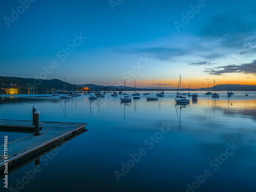 Sunrise over the water with boats and reflections © Merrillie