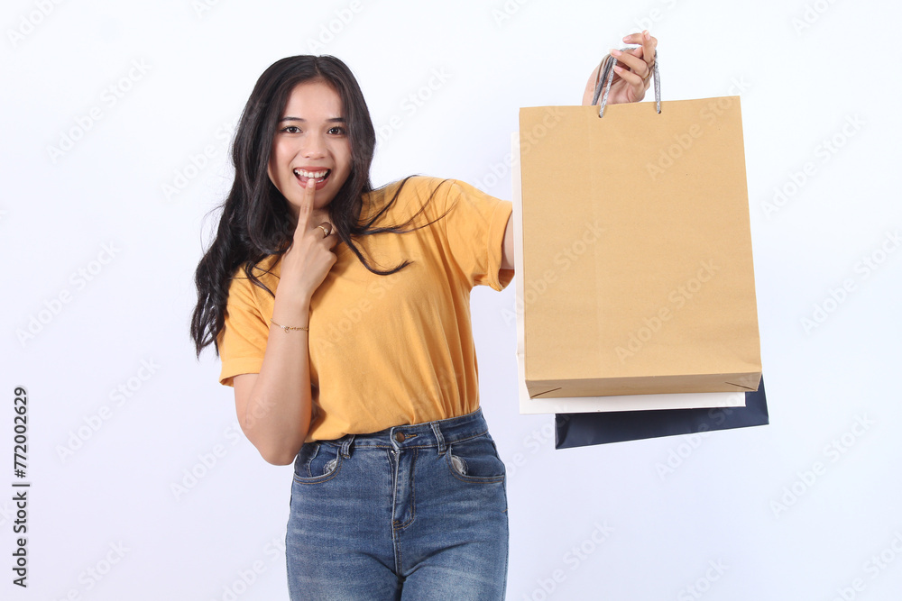 Asian happy female woman girl holds colourful shopping packages standing on white background studio shot, Close up Portrait young beautiful attractive girl smiling looking at camera with bags Asian happy female woman girl holds colourful shopping packages standing on white background studio shot, Close up Portrait young beautiful attractive girl smiling looking at camera with bags