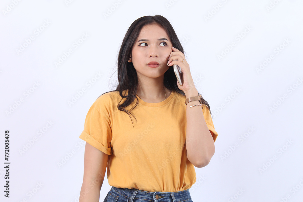Friendly smiling asian woman talking on phone, girl on call, holding smartphone and laughing, speaking, standing over white background Friendly smiling asian woman talking on phone, girl on call, holding smartphone and laughing, speaking, standing over white background