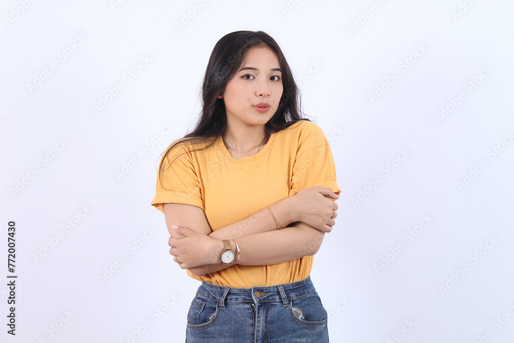 Asian Girl feeling uncomfortable walking light yellow t-shirt, hugging herself trembling, shaking feeling cold, freezing windy weather, frowning grimacing discomfort, stand white background Asian Girl feeling uncomfortable walking light yellow t-shirt, hugging herself trembling, shaking feeling cold, freezing windy weather, frowning grimacing discomfort, stand white background