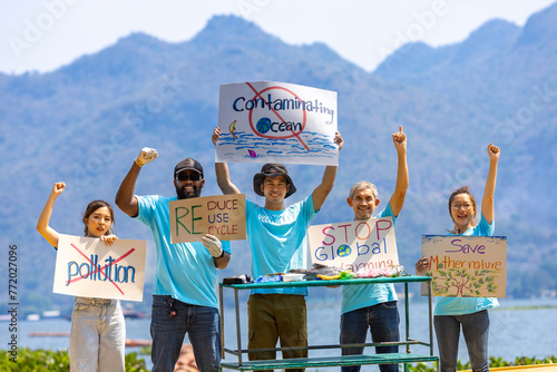 Team of ecologist volunteers are demonstrating rally at ocean for climate change and saving nature with protest sign against pollution and sea contamination for wildlife and biodiversity © Akarawut