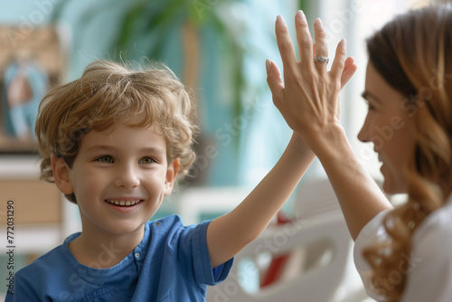 Happy cute little boy giving high five to pediatrician, friendly doctor greeting preschool patient at medical appointment, good checkup result, young mum and son visiting gp in hospital