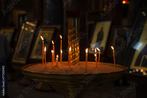Burning candles in front of icons