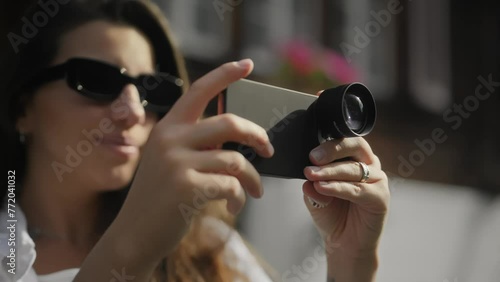 girl taking cell phone pictures. Portable Lens. Girl filming on a cell phone. A girl traveling mountainous terrain. Interchangeable lens. Portable lens on a cell phone. White shirt. Girl enjoying life