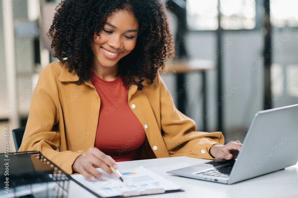 © Nuttapong punna - Confident business expert attractive smiling young woman holding digital tablet  on desk .