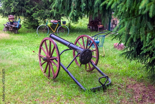 Homemade antique cannon close-up on the background of greenery in summer