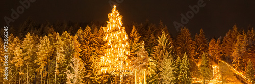Christmas or x-mas market at night with the tallest living Christmas tree in Europe at Neukirchen, Bavarian Forest, Hunderdorf, Straubing-Bogen, Bavaria, Germany photo