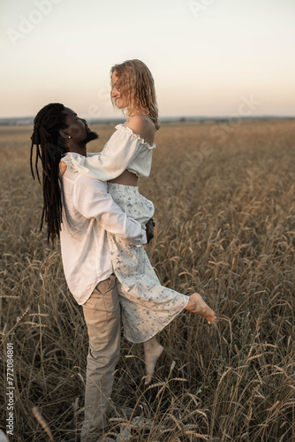 beautiful married couple of an African man and a Caucasian woman on a walk in the field	