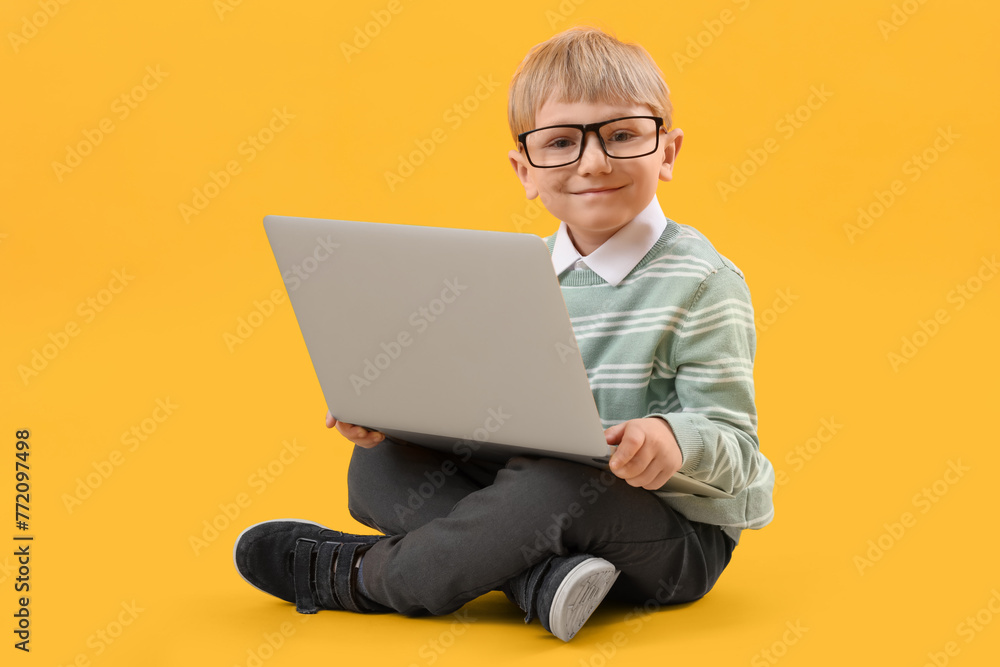 Funny little businessman with laptop sitting on yellow background Funny little businessman with laptop sitting on yellow background