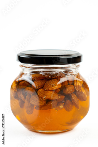 Jar of honey with nuts on white background