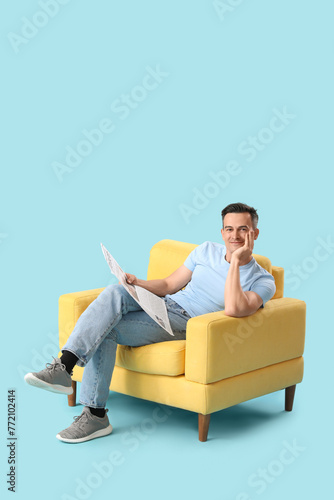 Handsome man reading newspa...