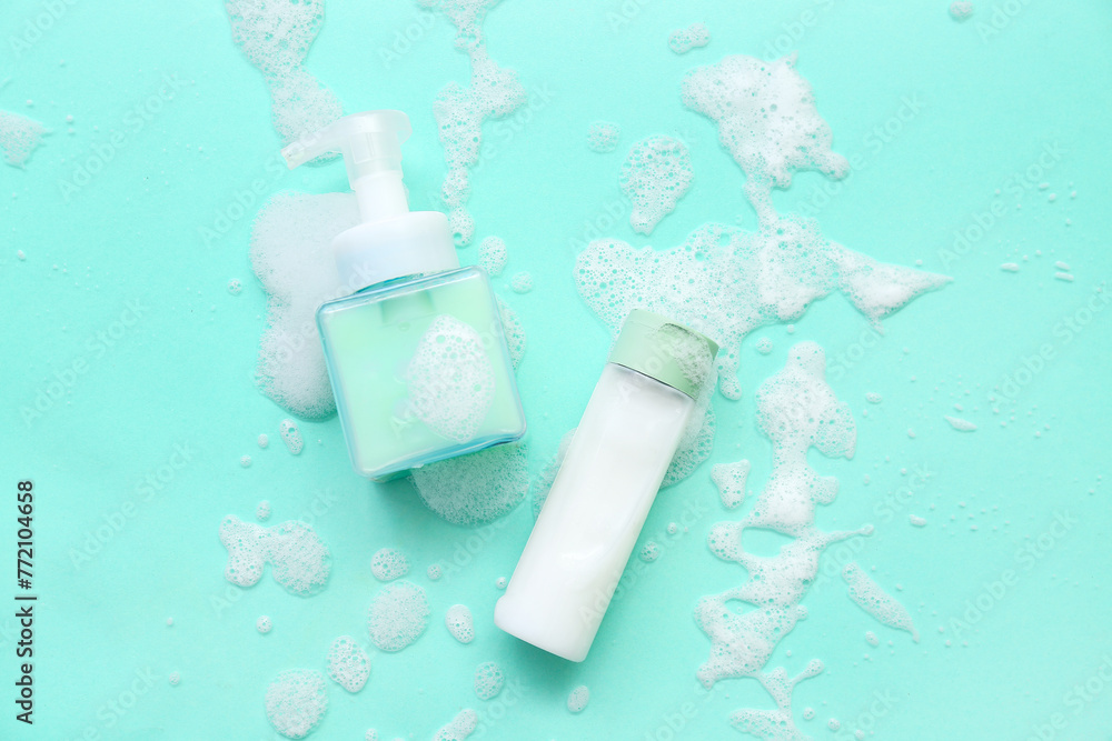 Bottles of cosmetic products with foam on turquoise background Bottles of cosmetic products with foam on turquoise background