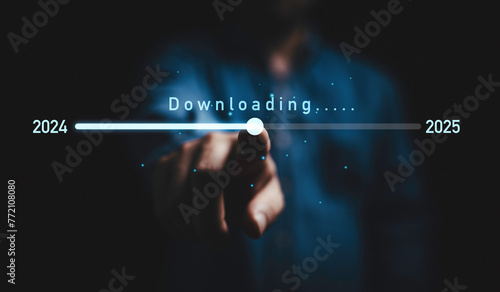 Businessman touching on download bar status to change from 2024 to 2025  for countdown of merry Christmas and happy new year by technology concept, Start new business and new life.