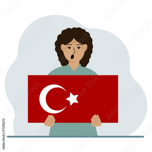 A woman holds a Turkish flag in his hands. Concept for demonstration, national holiday, Turkey day or patriotism. Nationality.