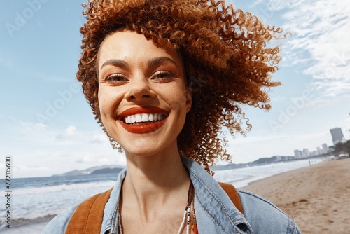 Joyful Afro Model with a Pretty Smile and Confident Expression, Laughing Outdoors in a Casual Attire on a Cool Summer Day, with Green Nature as a Stylish Background