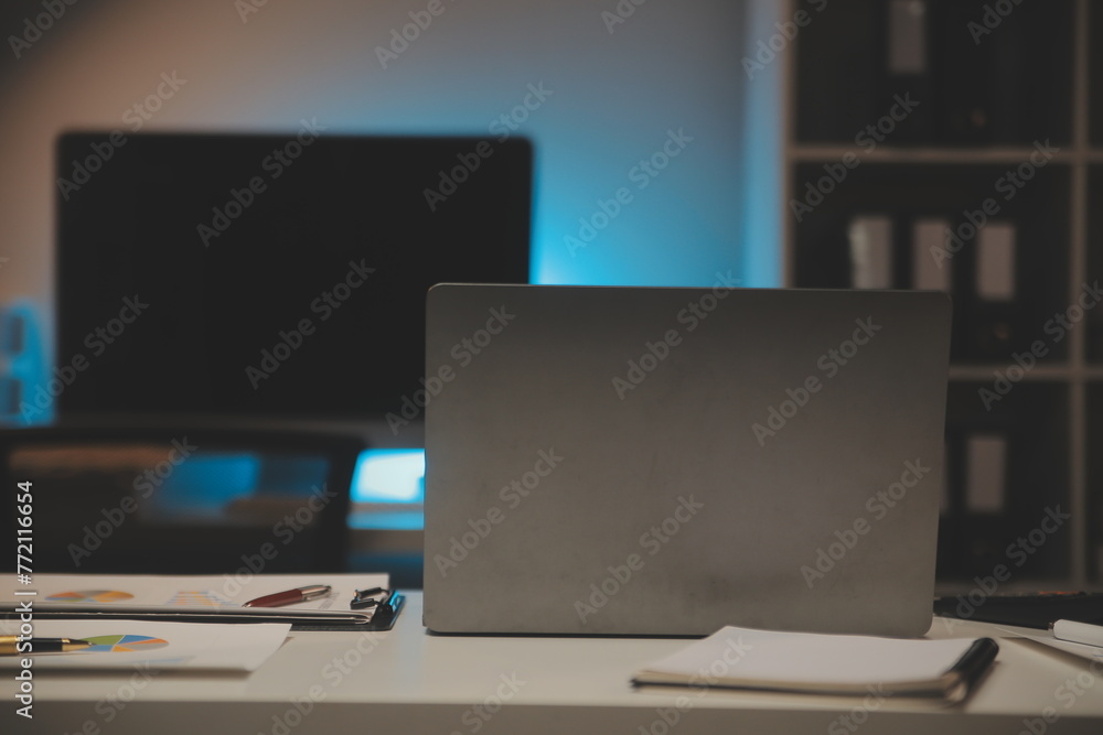 Laptop and paperwork on conference table Laptop and paperwork on conference table