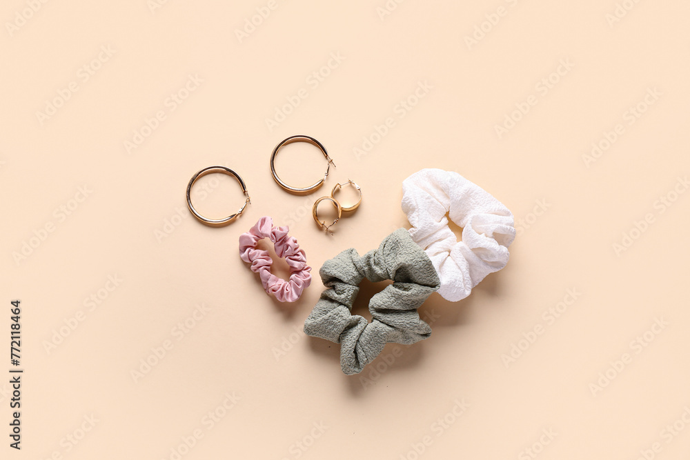 Silk scrunchies with earrings on beige background Silk scrunchies with earrings on beige background