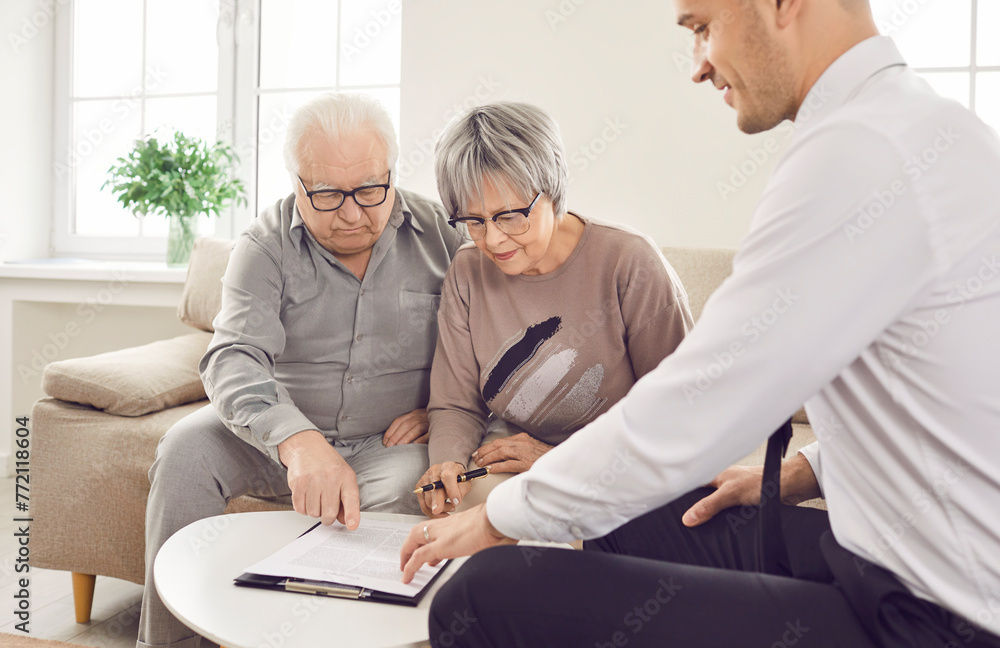 Obraz premium Senior pair and young consultant providing care, giving expert advice, signing documents help. Elder care consulting service, geriatric management for older people, financial counseling, social work