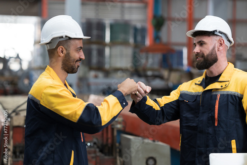 Two male engineers workers working in factory. Male workers discussing together in factory