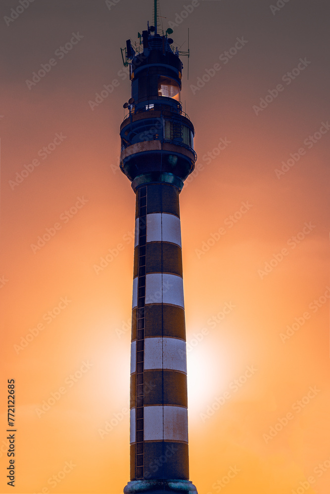 Fototapeta premium Lighthouse against the backdrop of sunset. Scarlet crimson sunset