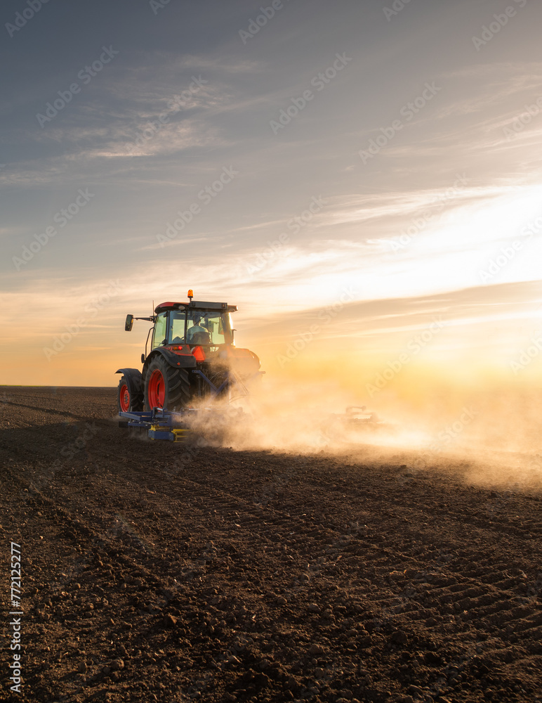 Naklejka premium Tractor preparing the land for a new crop planting