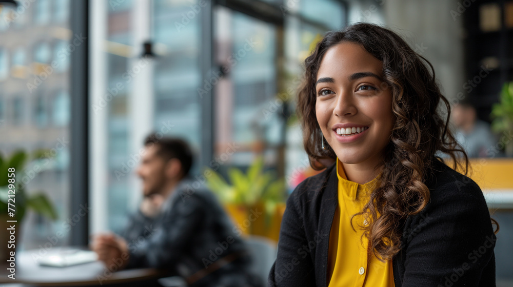 In a lively cowering space resonating with the hum of productivity, a smiling young businesswoman leans forward attentively while her partner speaks. In a lively cowering space resonating with the hum of productivity, a smiling young businesswoman leans forward attentively while her partner speaks.