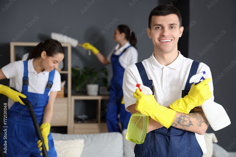 Male worker of cleaning service with detergents in room Male worker of cleaning service with detergents in room