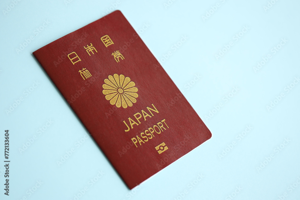 Japan passport on blue background close up. Tourism and citizenship concept Japan passport on blue background close up. Tourism and citizenship concept
