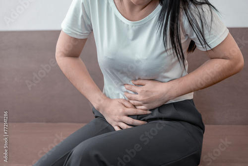 young woman hands in belly, stomach pain from food poisoning, abdominal pain and digestive problem, gastritis or diarrhoea. Abdomen inflammation, menstrual period people.