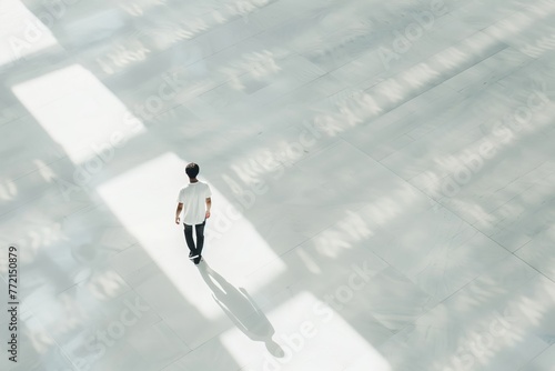 overhead photo of a man walking on a white floor photo