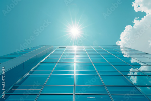 Modern Glass Skyscraper Against Clear Blue Sky with Flare