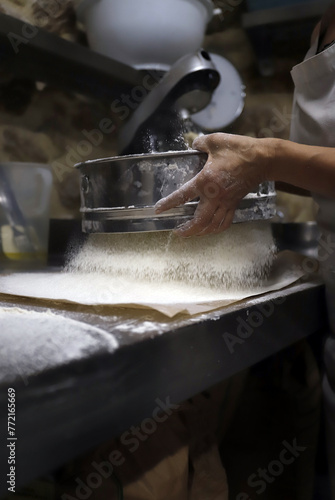 baker sifting flour to make bread