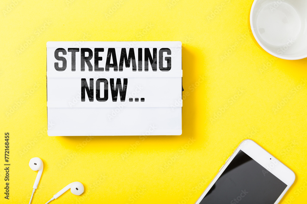 Streaming Now headline in notebook with electronic devces on yellow background