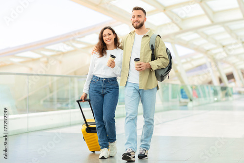Couple strolling with a yellow suitcase