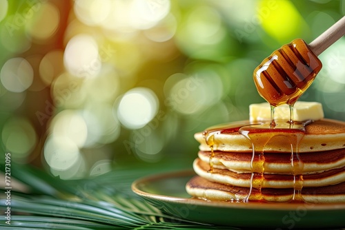 pancakes with honey and palm leaf on green bokeh background photo
