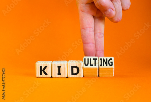 Kid or kidulting symbol. Concept words Kid or Kidulting on wooden cubes. Beautiful orange table orange background. Psychologist hand. Healthy lifestyle and kid or kidulting concept. Copy space.