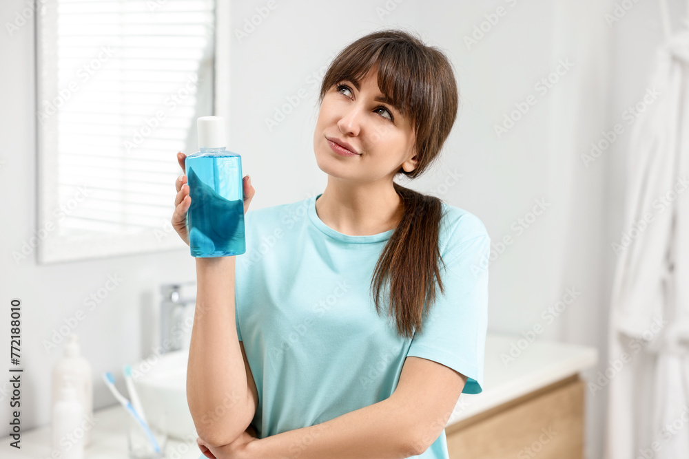 Young woman with mouthwash in bathroom. Oral hygiene Young woman with mouthwash in bathroom. Oral hygiene
