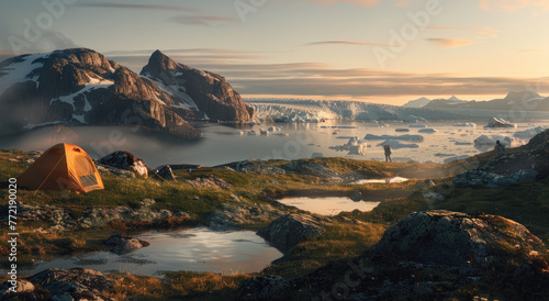 Camping in the arctic at a campsite with an orange tent on a grassy hill overlooking a valley and a small lake with people fishing in the distance and large icebergs floating