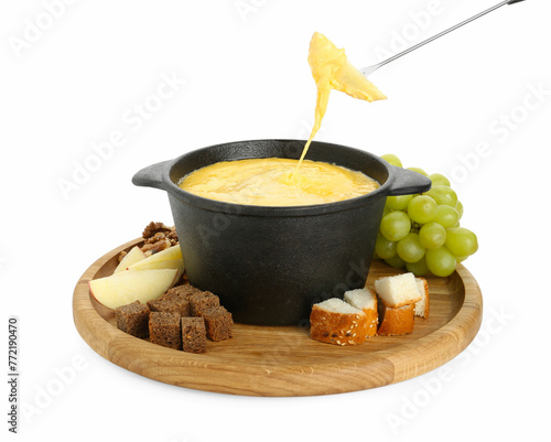 Dipping piece of apple into fondue pot with tasty melted cheese isolated on white