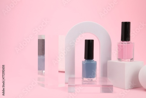 Stylish presentation of nail polishes on pink background