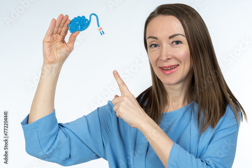 Model brain in hands of woman. Girl points to brain with socket. Woman reminds of importance of taking care of intellect. Brain symbolizes human mind and memory. Lady offers to recharge your memory