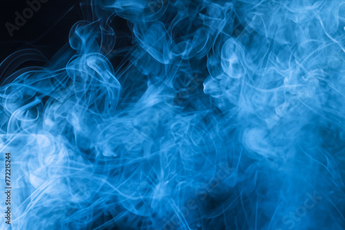 Smoky Blue Background. Blue smoke abstract background close up. Texture of smoke vape on black background. © Fernando Astasio