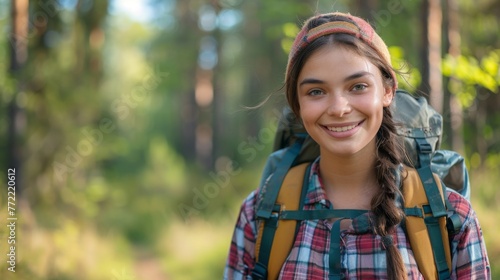 Portrait of a chubby healthy confident smiling teenage girl with backpack hiking in forest
