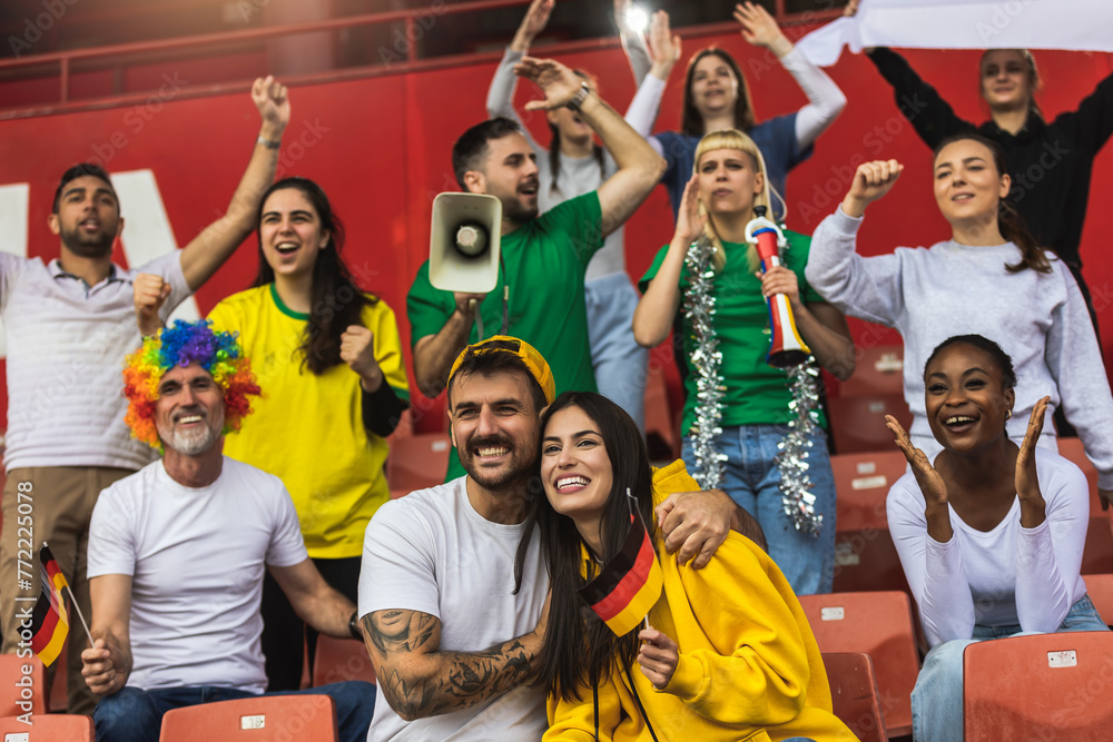 German football / soccer fans cheering at the stadium with flags and other equipment