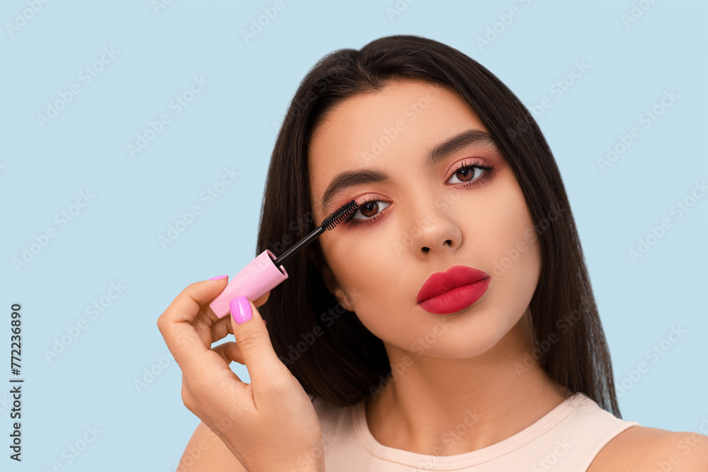 Beautiful young woman with stylish mascara on blue background Beautiful young woman with stylish mascara on blue background